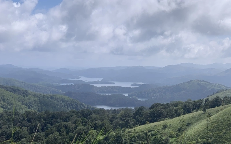 Panoramic view of mist-covered mountain valleys and forest slopes in Vagamon