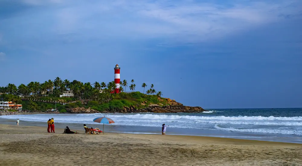 Red and white striped Kovalam lighthouse overlooking the ocean beach in Kerala