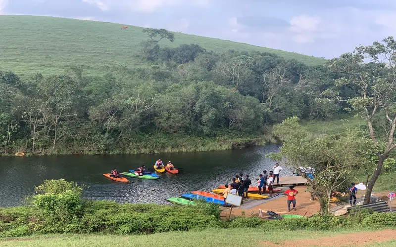 Tourists enjoying boating on peaceful Vagamon lake surrounded by hills